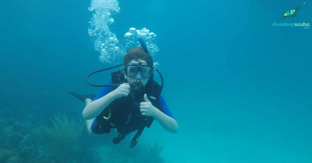 Young scuba diver showing thumbs up