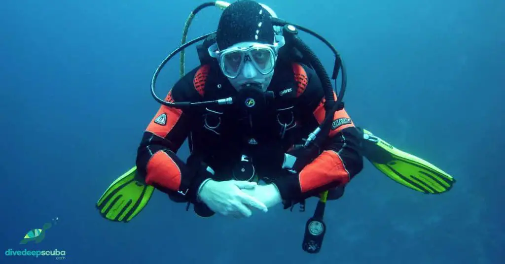 Scuba diver in thick suit in the blue