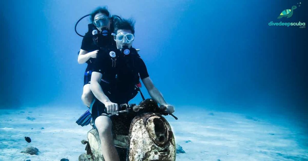 scuba divers on a bike underwater
