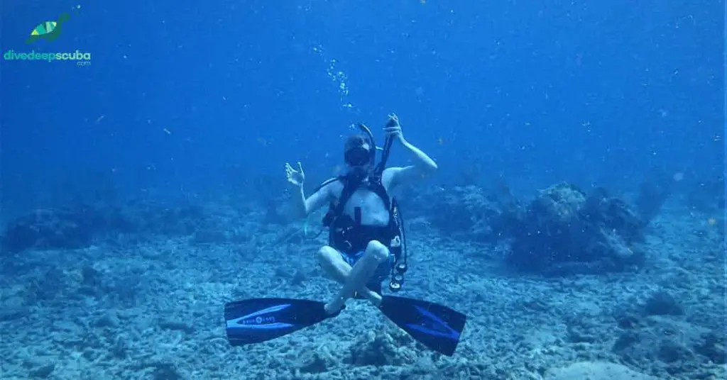 Scuba diver at the sea floor in hover position