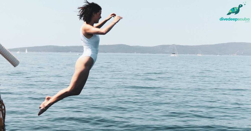 woman jumping into the ocean