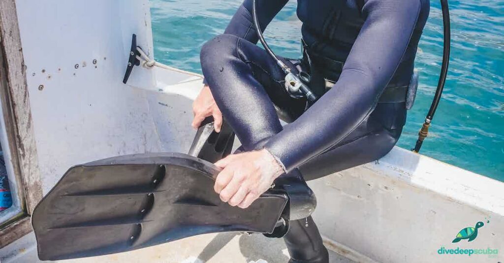 picture of a scuba diver putting on fins