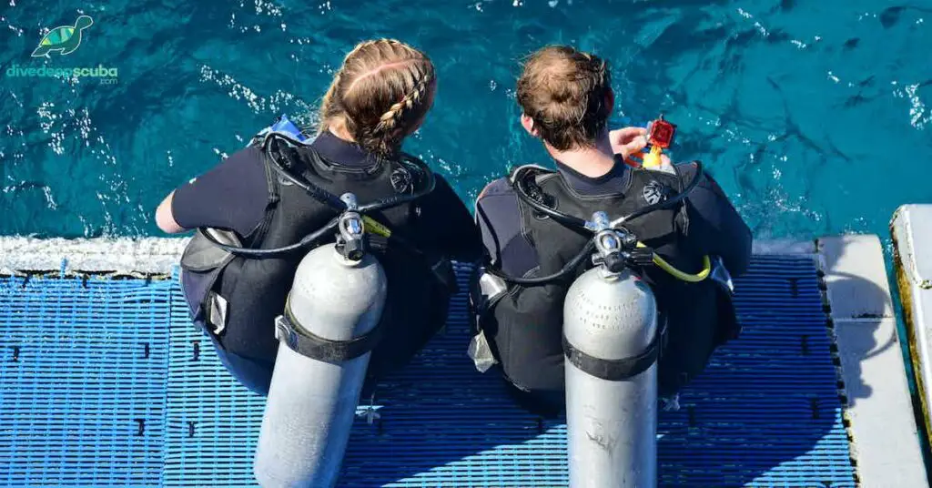 picture of two scuba divers on the edge of the boat